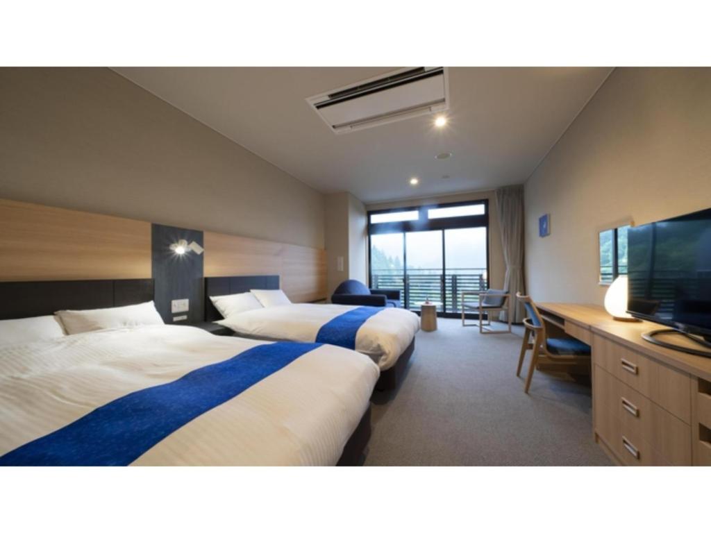 een hotelkamer met 2 bedden en een flatscreen-tv bij Hotel Sekisuien - Vacation STAY 44681v in Gujo