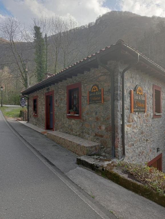 ein kleines Steingebäude an der Seite einer Straße in der Unterkunft Casa Villastur in Covadonga