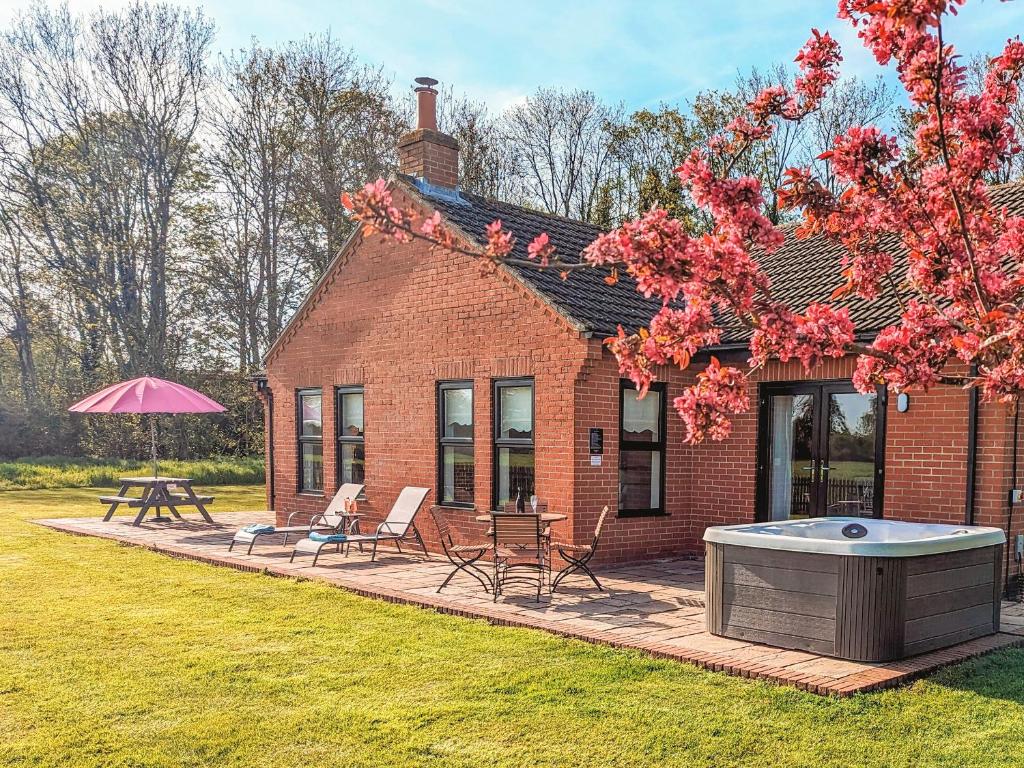 a brick house with a hot tub in the yard at Highgrove in Gissing