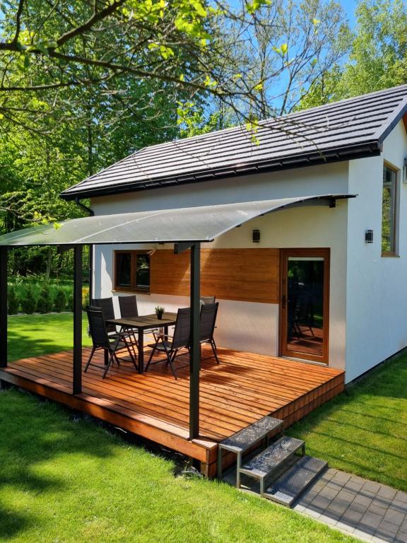 ein Haus mit einer Terrasse mit einem Tisch und einem Sonnenschirm in der Unterkunft Kameralny in Przeciszów