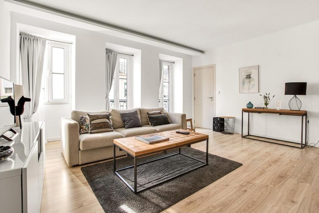 a living room with a couch and a table at Modern 2 Bedroom Apartment in Estrela with Outside Terrace! Amazing for Families, Couples, Friends in Lisbon