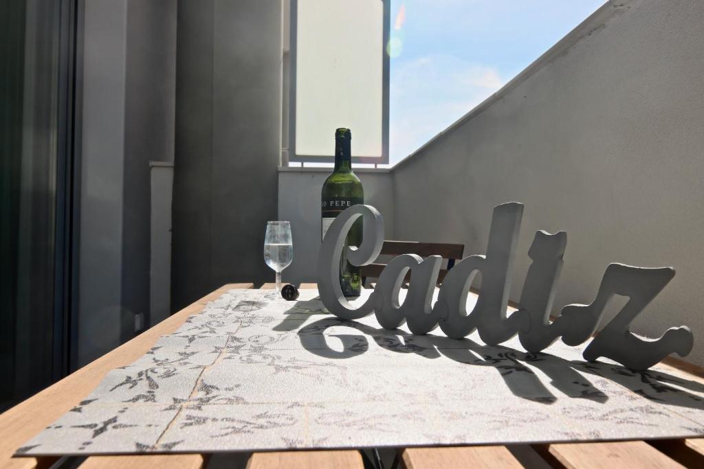 eine Flasche Wein und ein Glas auf dem Tisch in der Unterkunft Apartamento San Leonardo Playa (Free Parking) in Cádiz