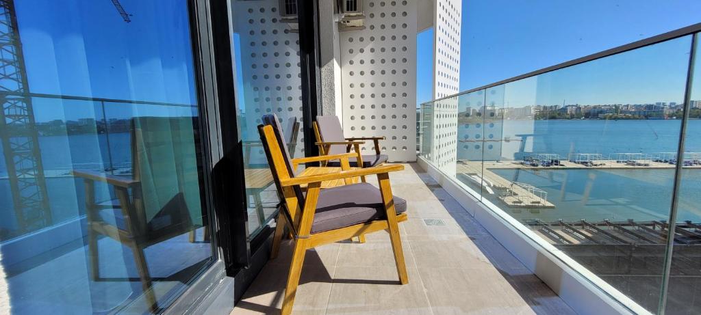 a wooden chair sitting on the balcony of a building at Aqua Magic Lake On Luminita Studio in Mamaia