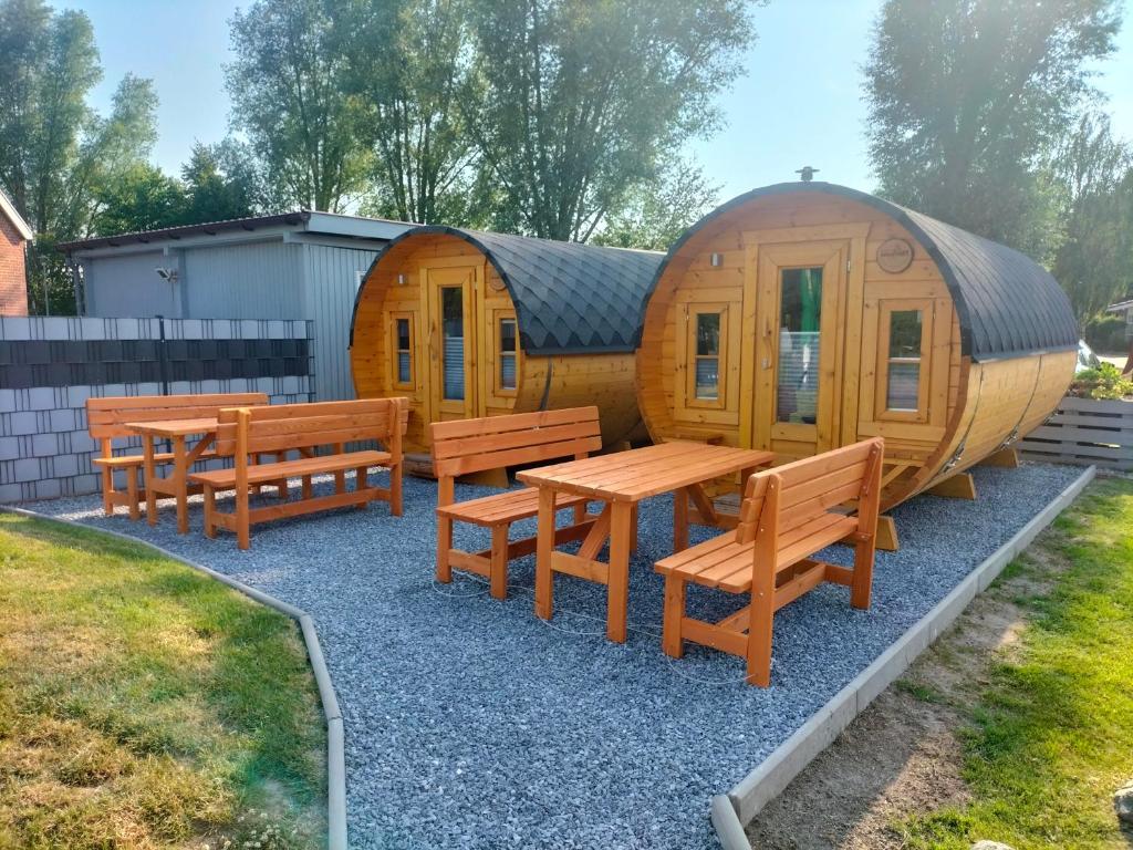 Cabaña de madera con bancos y mesa en Campingfässer Weener en Weener