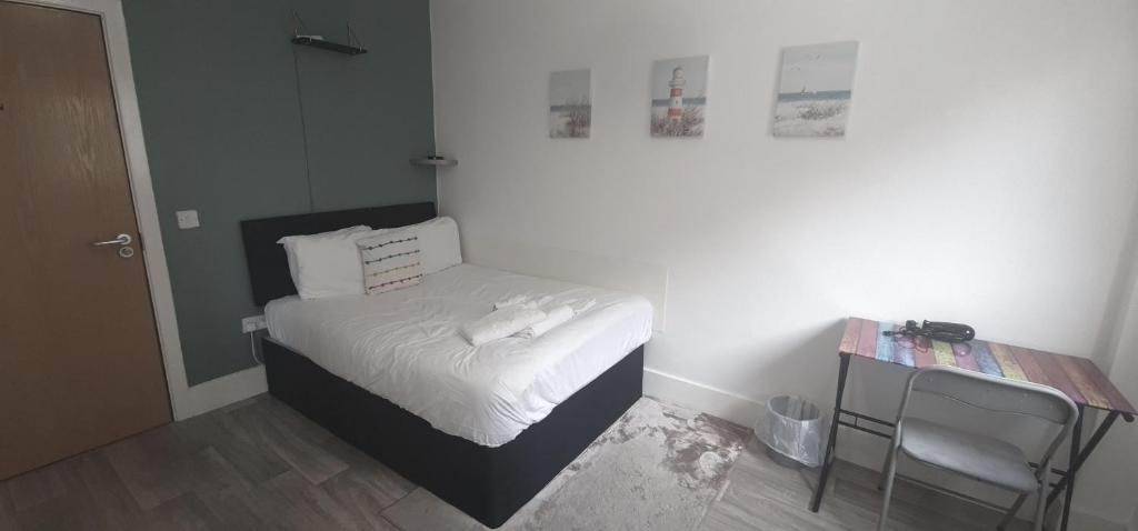 niewielka sypialnia z łóżkiem i stołem w obiekcie Neon 160 w mieście Swansea