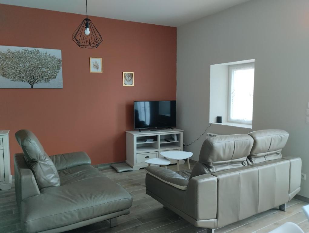 - un salon avec un canapé, des chaises et une télévision dans l'établissement Au cocon Chapellois, à La Chapelle-Saint-Mesmin