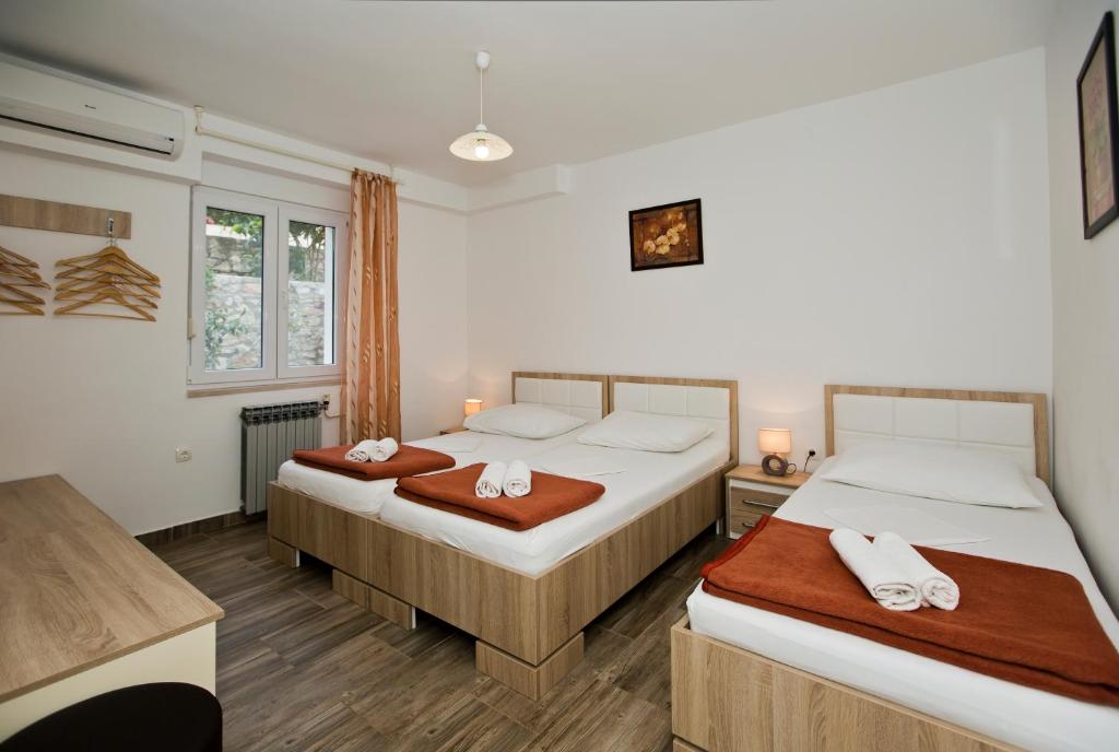 een slaapkamer met 2 bedden en handdoeken bij Guesthouse Aurora in Hvar