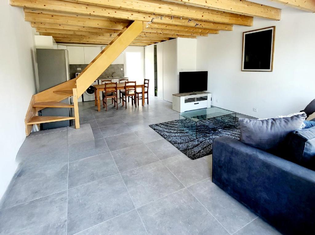 uma sala de estar com um sofá e uma mesa em Maison Confort et détente em Tavaco