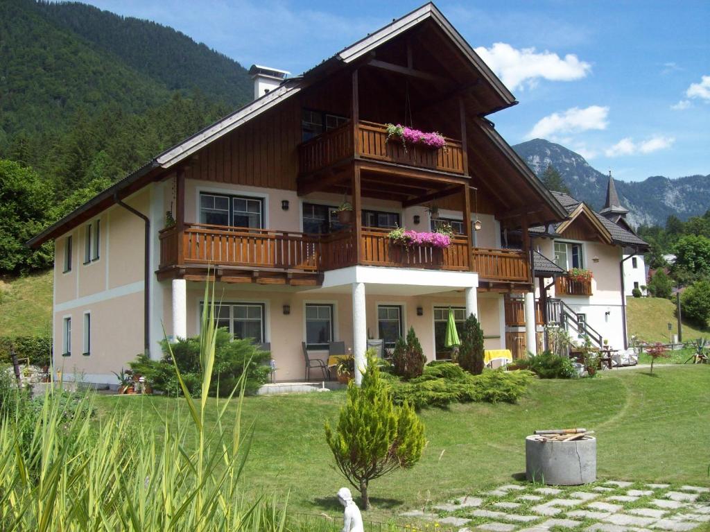a large house with a balcony on top of a yard at Apartmenthaus Simmer in Obertraun