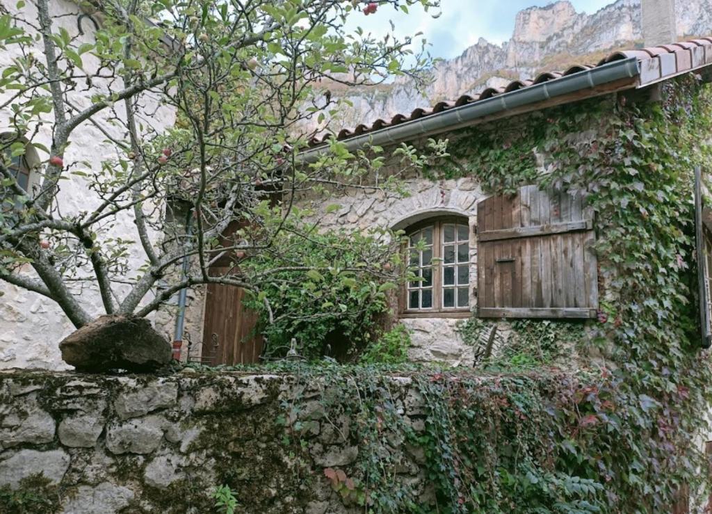 een ivoren gebouw met een raam en een hek bij La Maisonnette d'Archiane in Châtillon-en-Diois