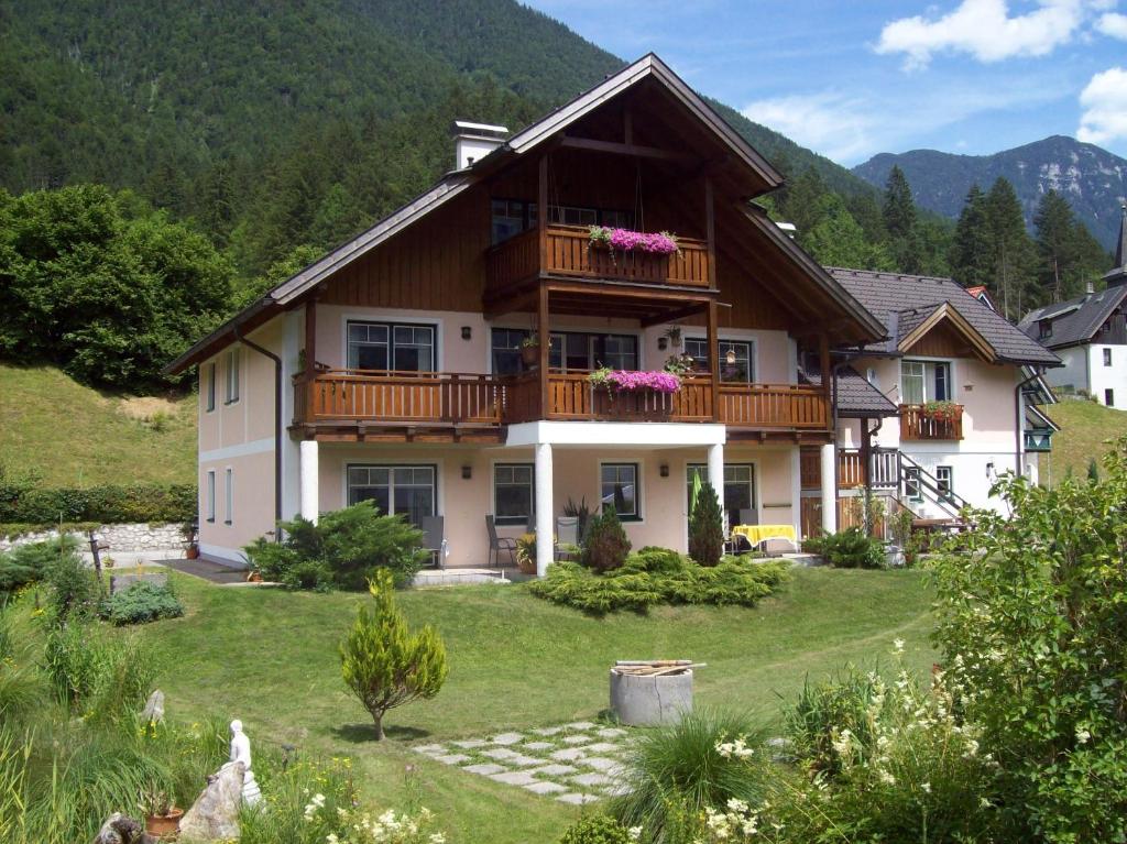 a large house with a balcony on top of a yard at Apartmenthaus Simmer in Obertraun