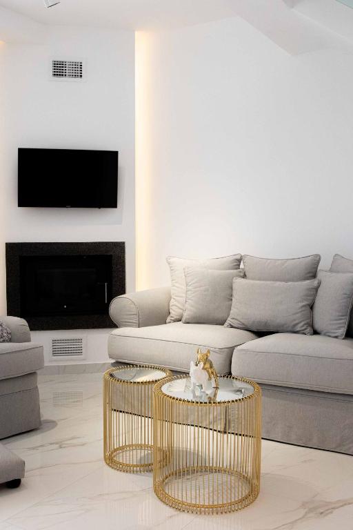 a living room with a couch and a table at DK Luxury Suite in Nea Peramos