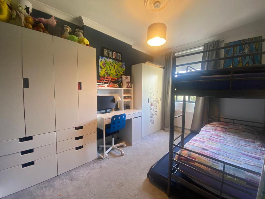 a bedroom with a bunk bed and a desk at Three Bedroom Family home with garden in Walthamstow in London