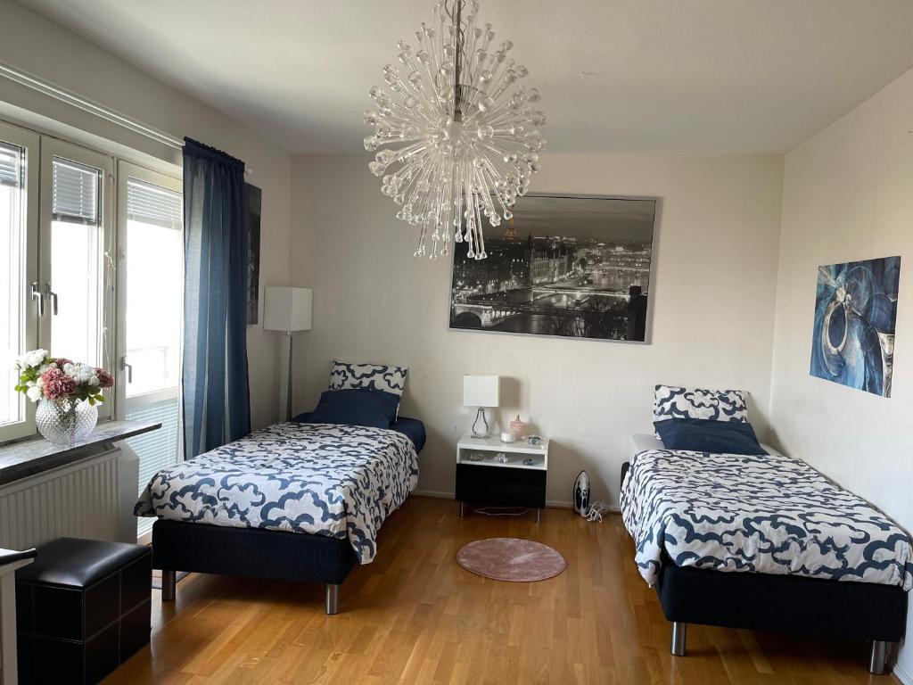 a bedroom with two beds and a chandelier at Tway luxury homes in Jönköping