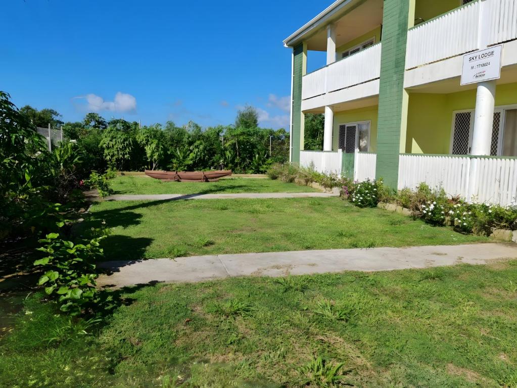 a green building with a bench in the yard at Sky Lodge in Nuku‘alofa