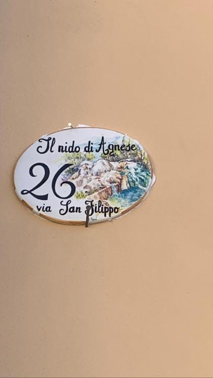 un cartel en una pared que dice que está sostenido en Il nido di Agnese, en Bagni San Filippo