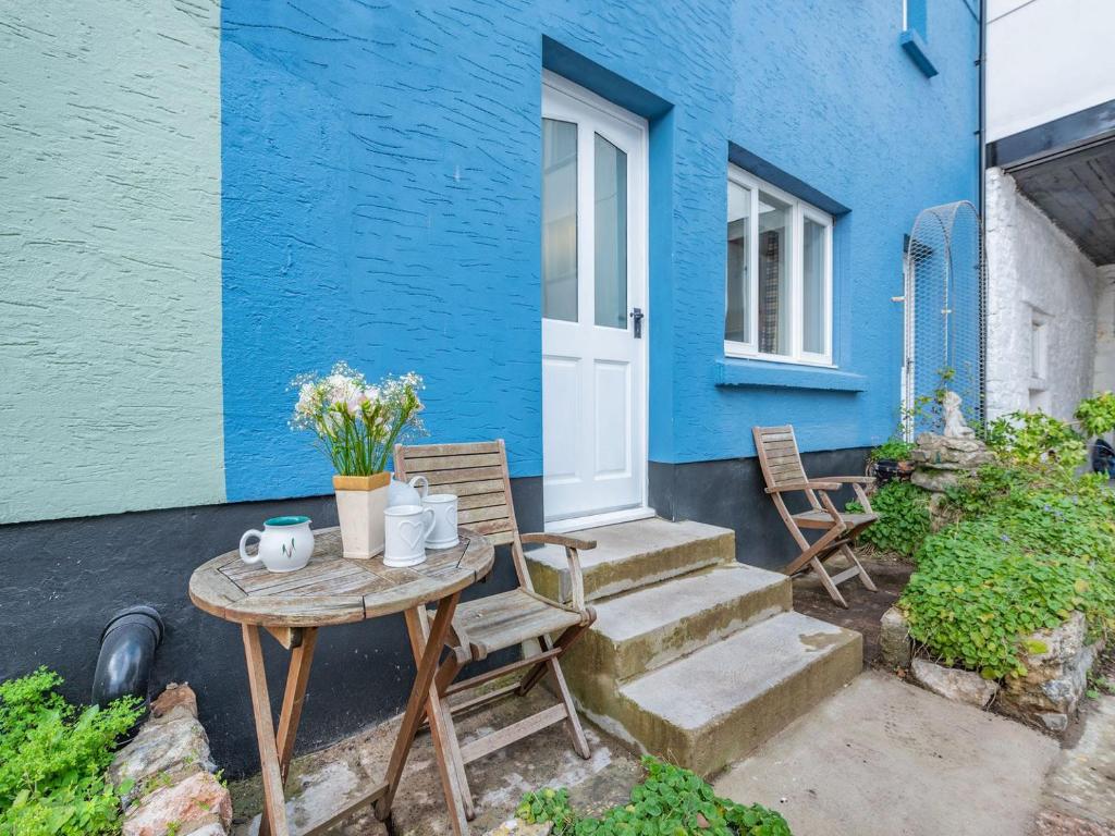 a blue house with a table and chairs in front of it at 1 Cromwells Cottage-uk40925 in Pembroke