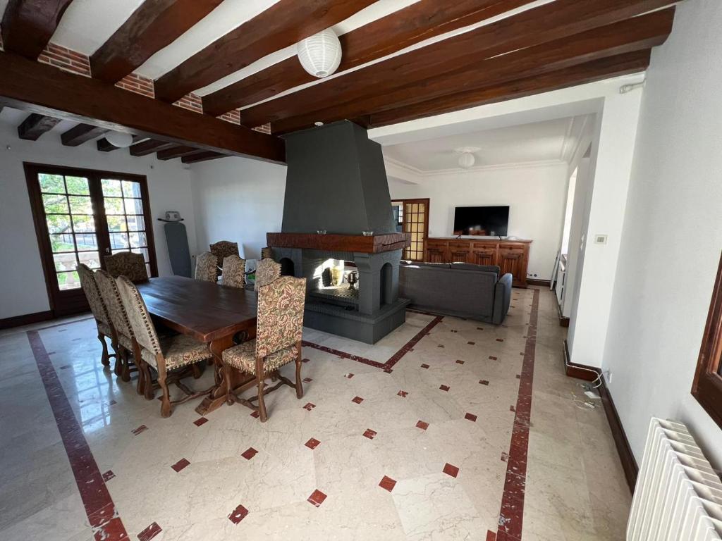 uma sala de estar com uma mesa e uma lareira em Auberge Mer em Mer