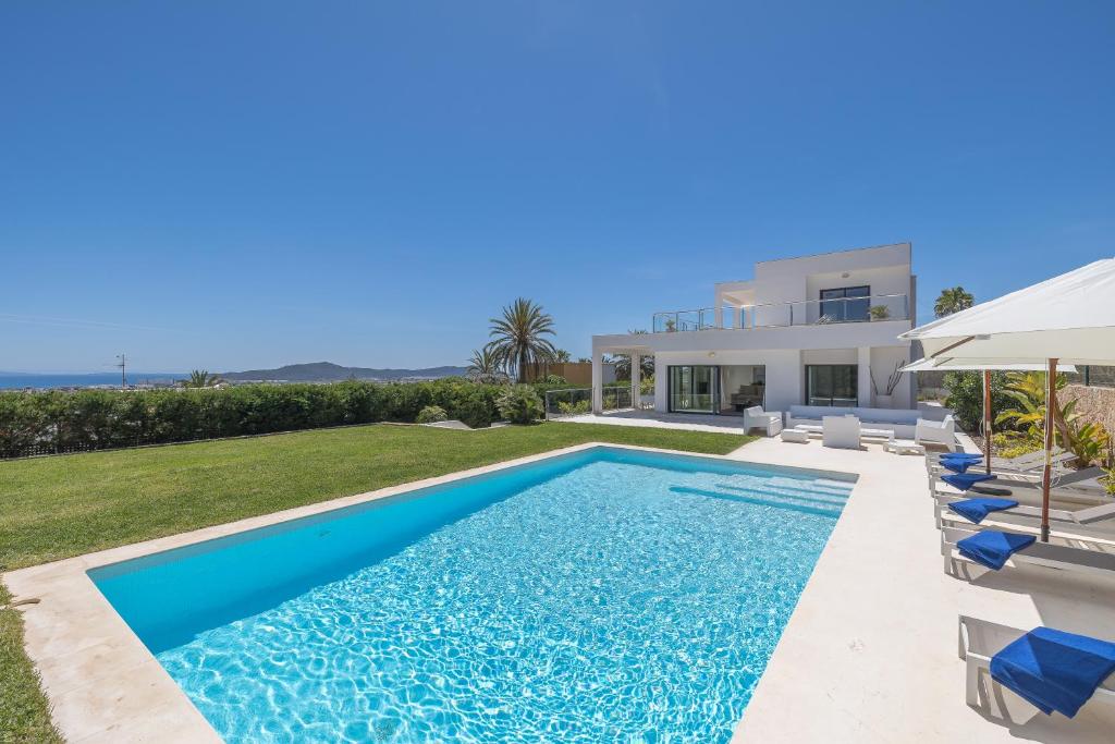 Villa con piscina frente a una casa en Villa con vistas al mar, en Sant Jordi
