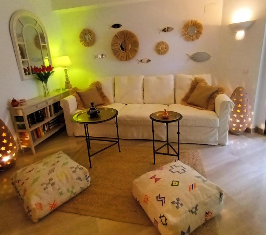 a living room with a white couch and two tables at La Cueva Beach in Altafulla