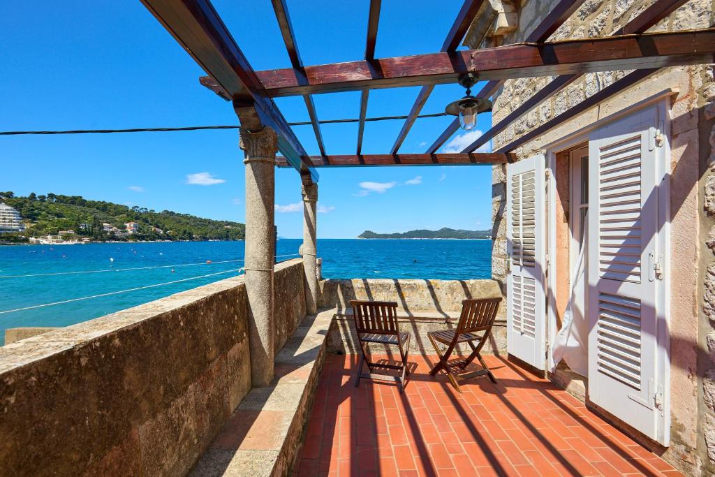 a balcony with chairs and a view of the water at La Villa Lopud- Breakfast & Dinner Included in Lopud