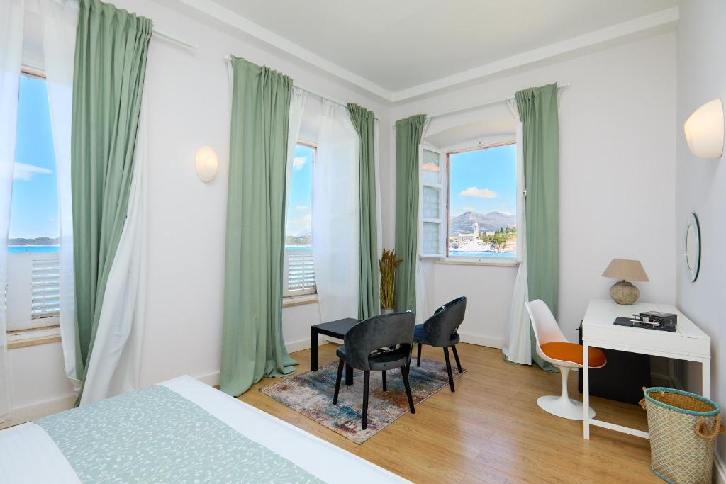 1 dormitorio con 1 cama, escritorio y ventanas en Bed & Breakfast- La Villa Lopud, en Lopud Island