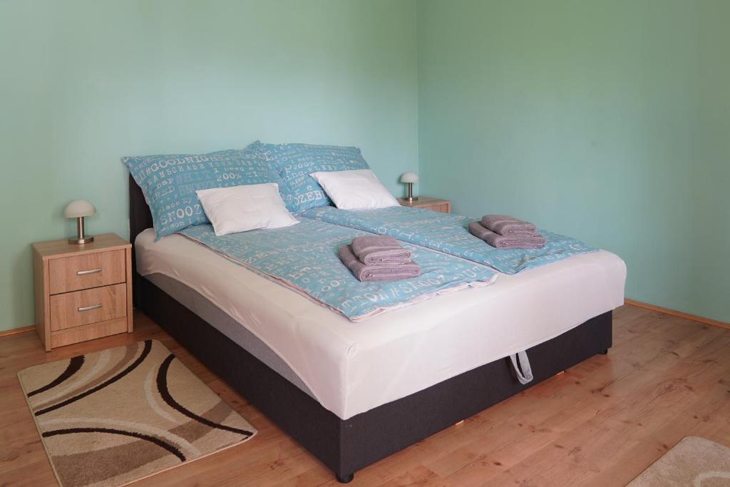 a bedroom with a bed with towels on it at Dia Apartman Pécs in Pécs