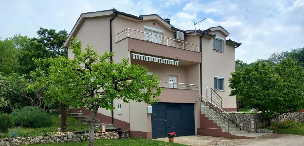 a large house with a blue garage at On the river Imotski Baška Voda in Imotski