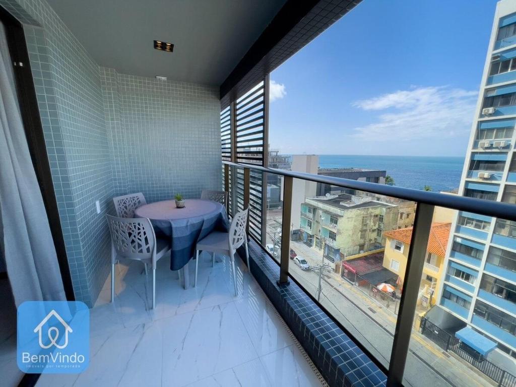 a balcony with a table and a view of the ocean at Apartamento com linda vista mar no Smart Barra 2 in Salvador