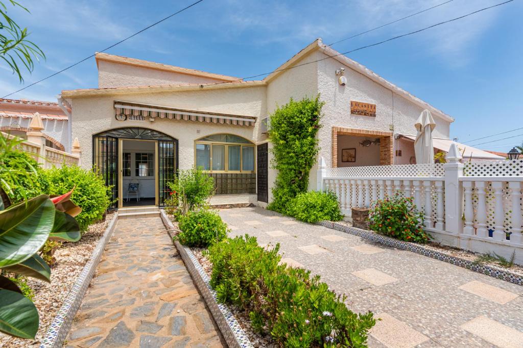 una casa con una recinzione bianca e un vialetto di Beautiful house with sea views and private pool a Torrevieja