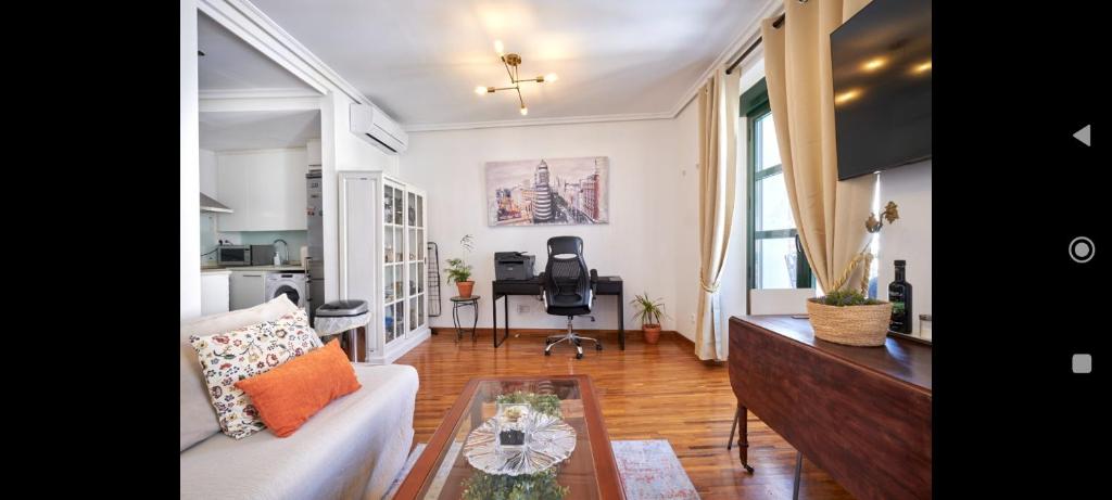 uma sala de estar com um sofá e uma mesa em MAD COCO Vintage Apartment Madrid em Madri
