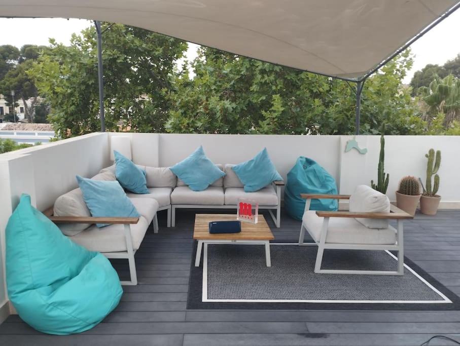 - un canapé avec des oreillers bleus assis sur une terrasse dans l'établissement Maravillosos Atico, à Godella