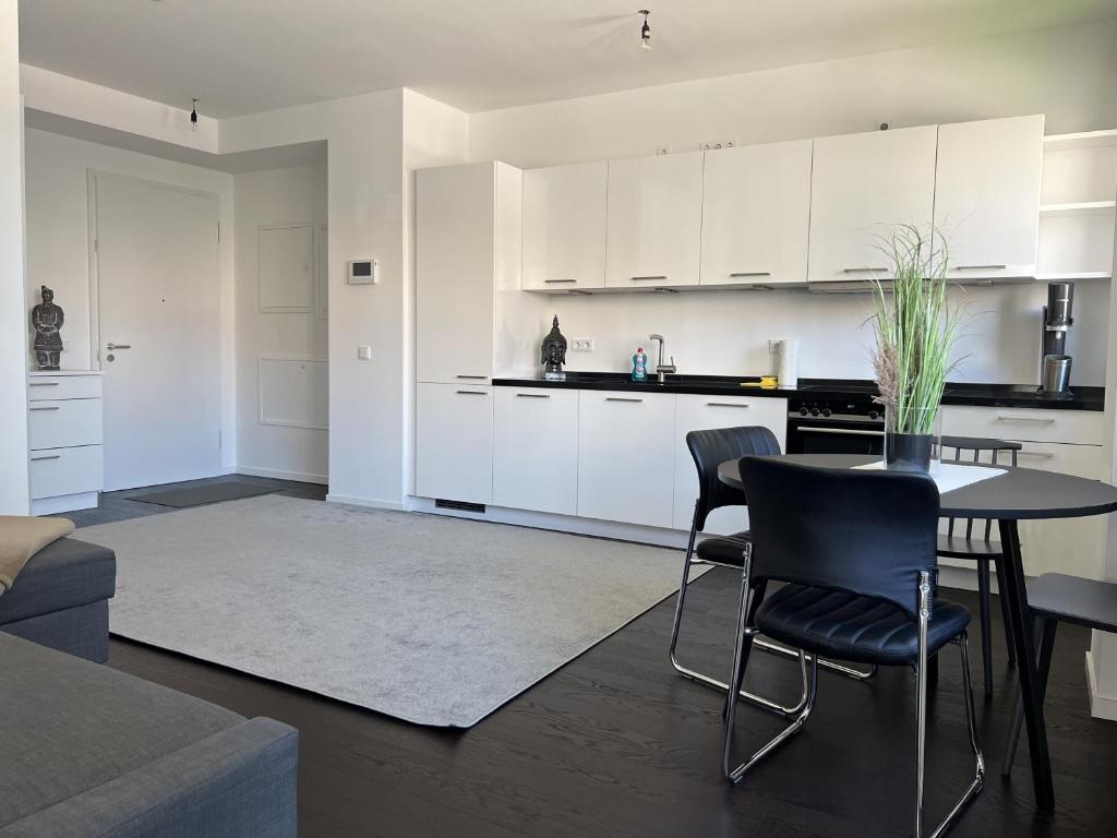 a kitchen with white cabinets and a table and chairs at Luxury Waterfront Apartment in Berlin