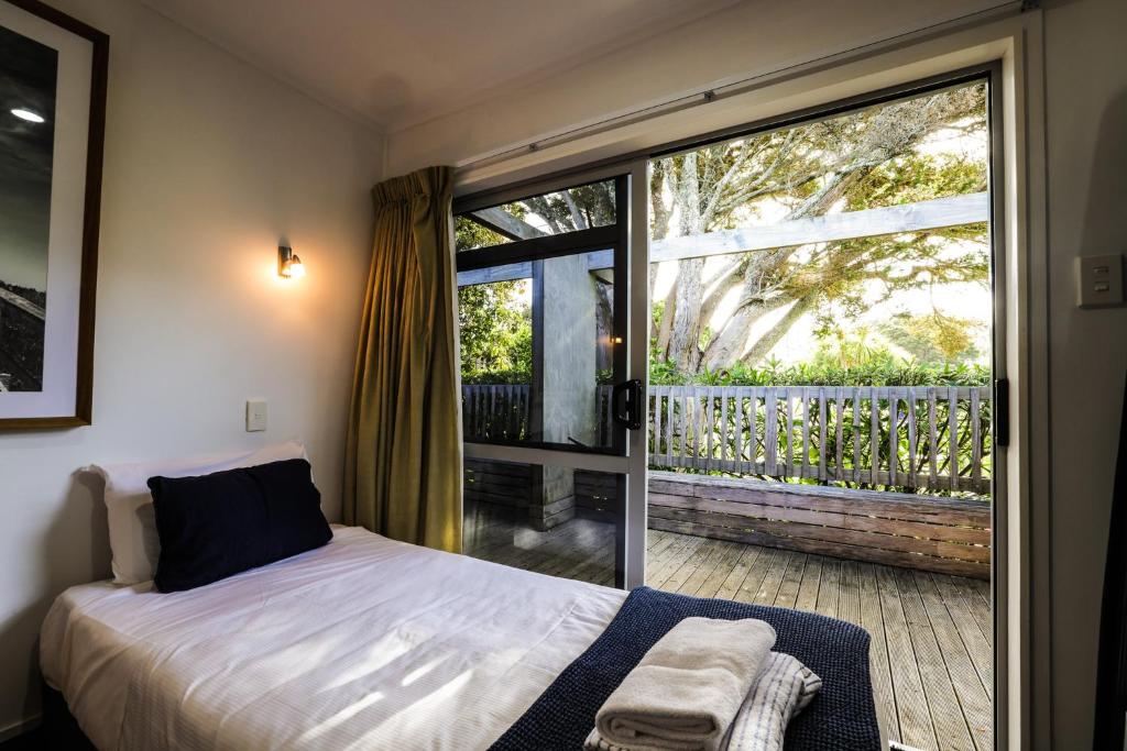 a bedroom with a bed and a large window at Tasman Holiday Parks - Waihi Beach in Waihi Beach