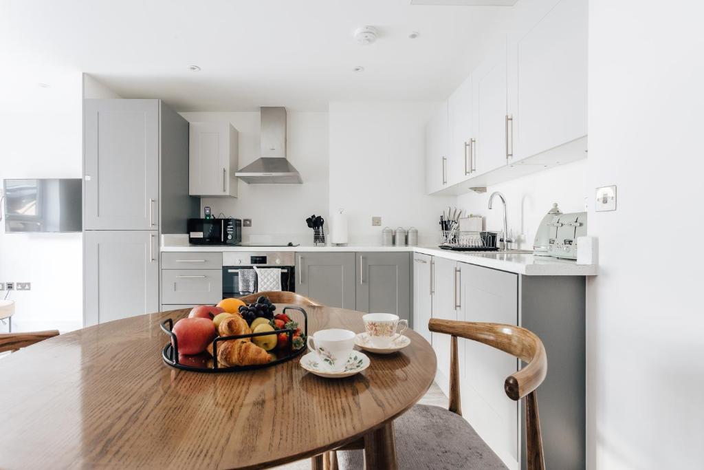 una cocina con una mesa de madera y un bol de fruta en Lovely one bed duplex flat, en Bournemouth