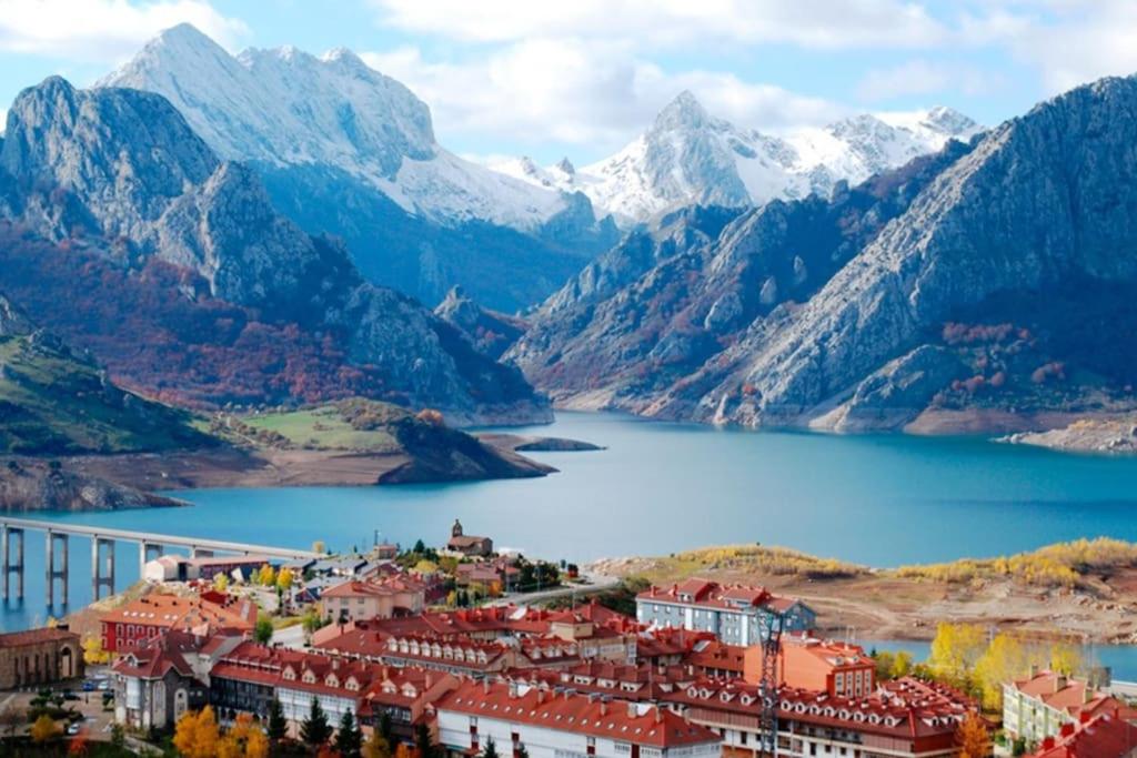 a town in front of a lake and mountains at Piso en Picos de Europa - Riaño Licencia VUT-LE-818 in Riaño