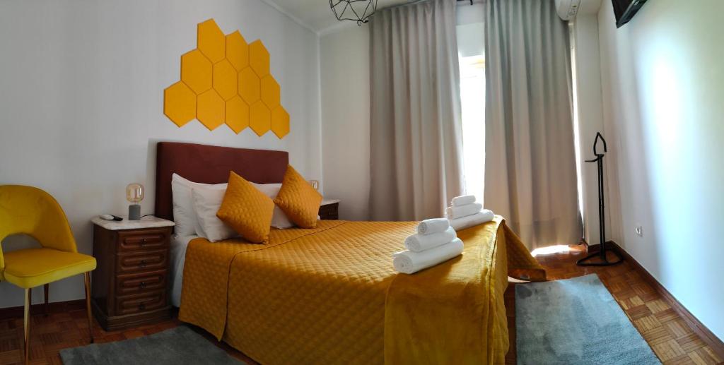 sypialnia z żółtym łóżkiem i żółtym krzesłem w obiekcie Casa Valadim w mieście Chaves