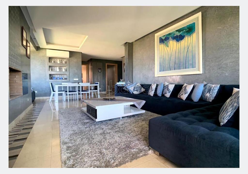 Apartment for rent in Marrakech في مراكش: غرفة معيشة مع أريكة سوداء وطاولة