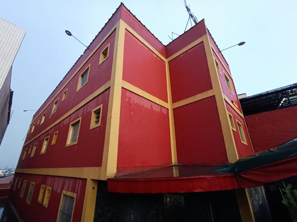 un edificio rojo y amarillo con un edificio rojo en Hotel Novo México en Guarulhos