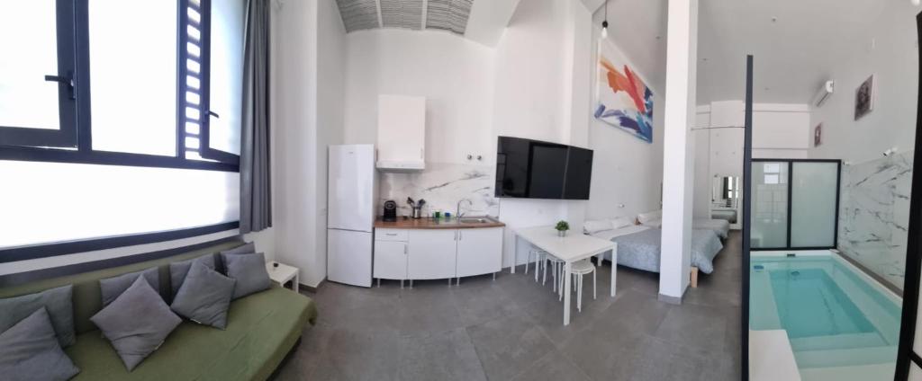 uma sala de estar com um sofá, uma cozinha e uma banheira em Loft familiar "PISCINA SEVILLA CENTRO" em Sevilha