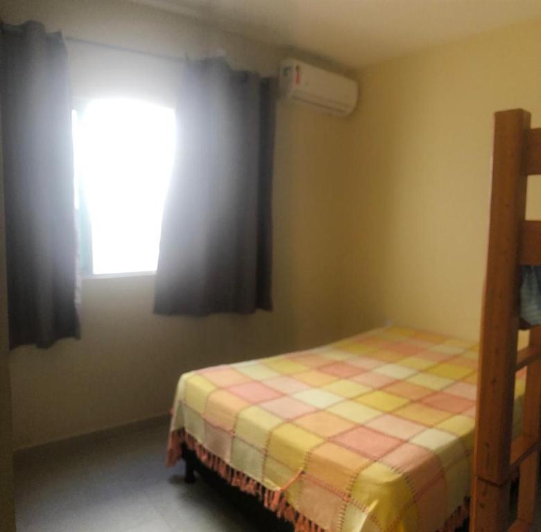 a small bedroom with a bed and a window at Carapibus, Conde PB in Conde