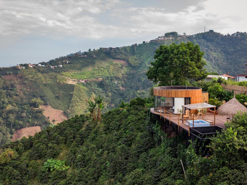 une maison au sommet d'une colline avec des arbres dans l'établissement Atardeceres del Cafe, à Manizales