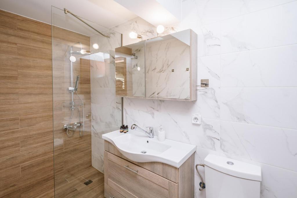 e bagno con lavandino, servizi igienici e doccia. di Unique1 - Private Lux city apartment a Heraklion