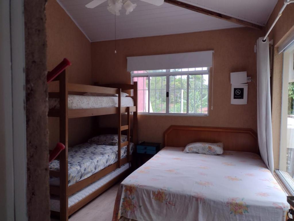 a bedroom with two bunk beds and a window at Suite Hanaki com microondas e frigobar in Ubatuba
