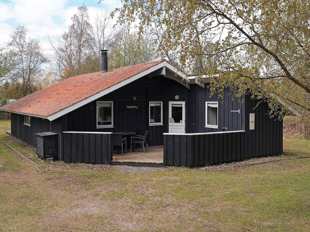 una casa negra con una mesa delante en 6 person holiday home in Gedser en Gedser