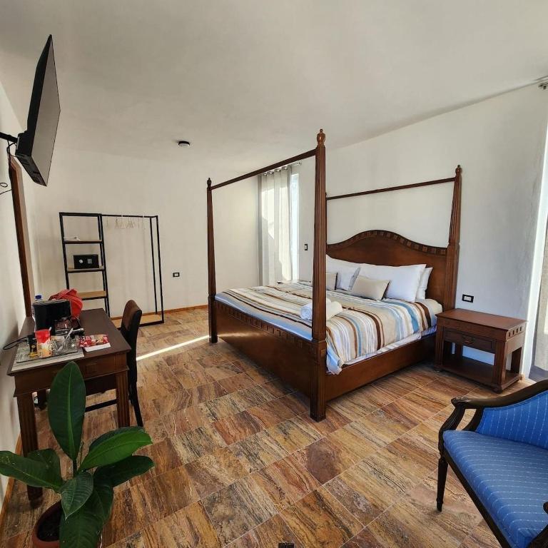 a bedroom with a bed and a table and a couch at Habitacion Privada, 5 min Catedral in Mérida