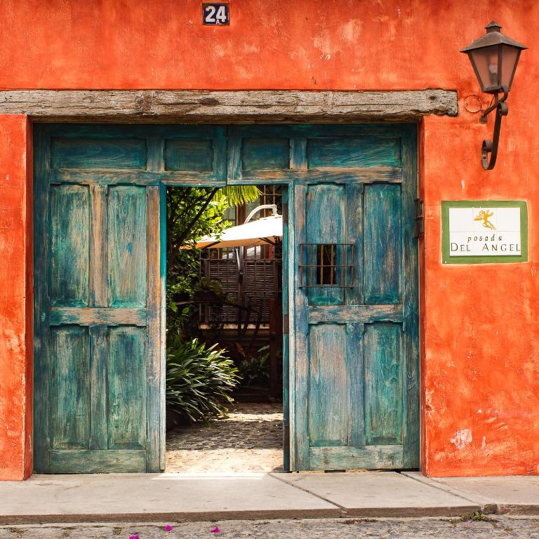 an orange building with an old wooden door at Posada del Angel in Antigua Guatemala