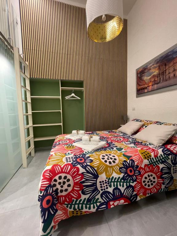 um quarto com uma cama grande e um cobertor colorido em Hrdo House em Siracusa