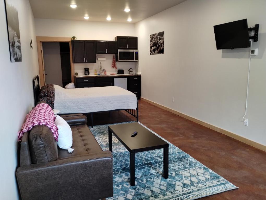 een kleine woonkamer met een bed en een bank bij Grewingk Suite - Homer Seaplane Base in Homer