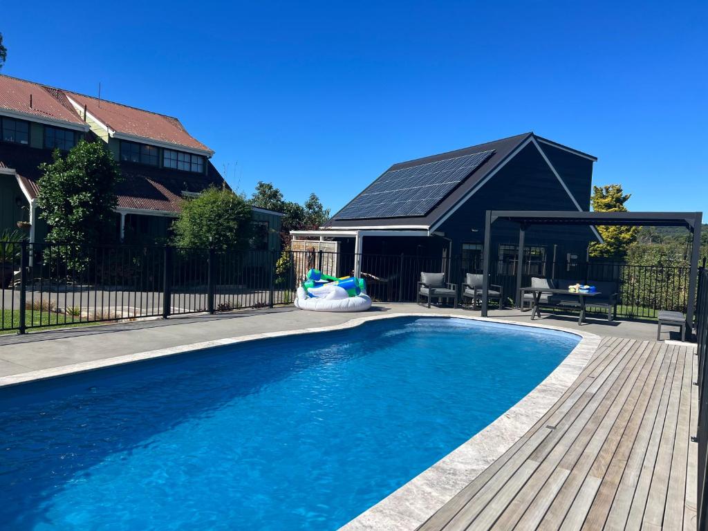 a swimming pool in front of a house at Bright Cosy Cottage in Whitianga